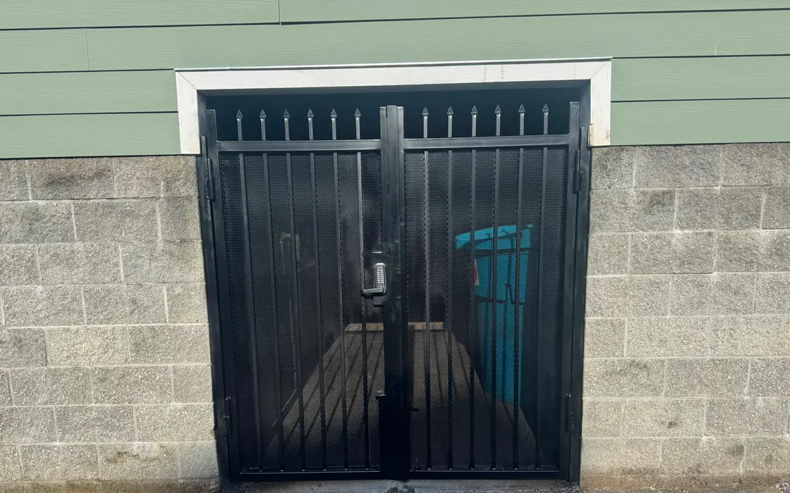 Black steel double security gate with spear tops and keypad on block wall. Fence & gate installation in Tigard