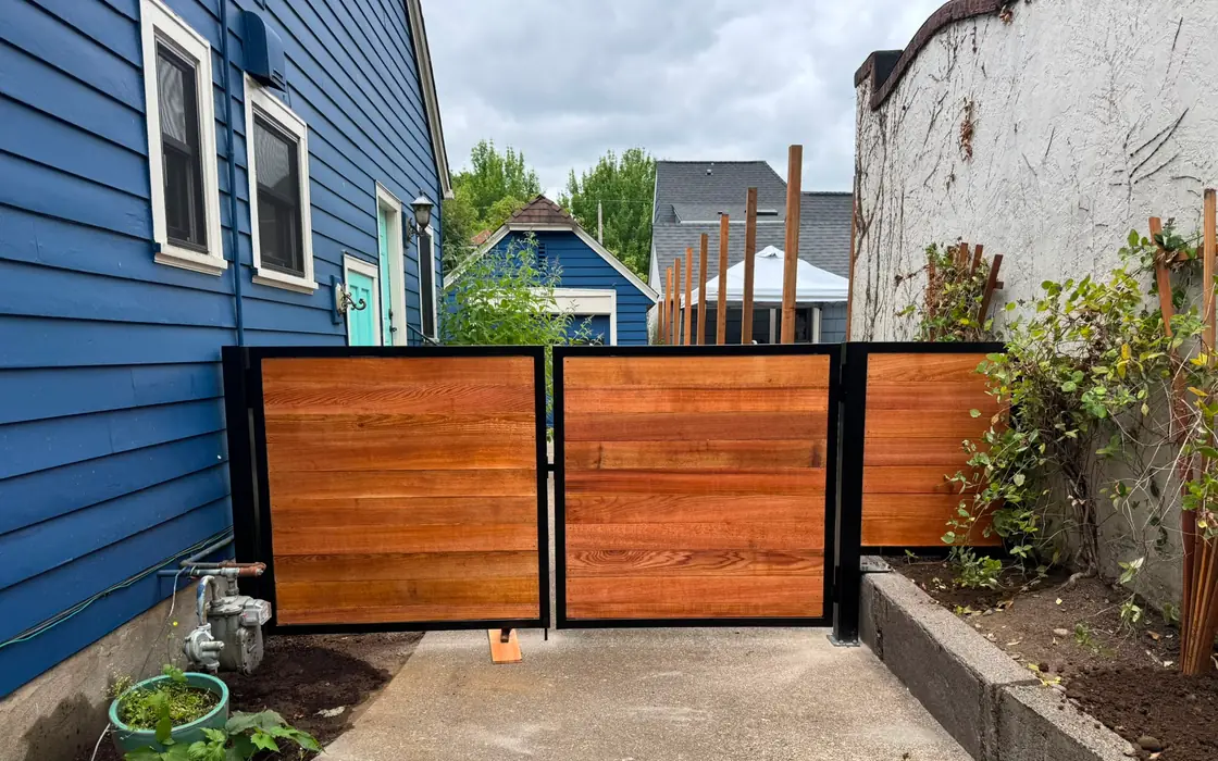 Finished cedar horizontal swing driveway gate in black frame, straight-on view. Fence & gate installation in Tualatin