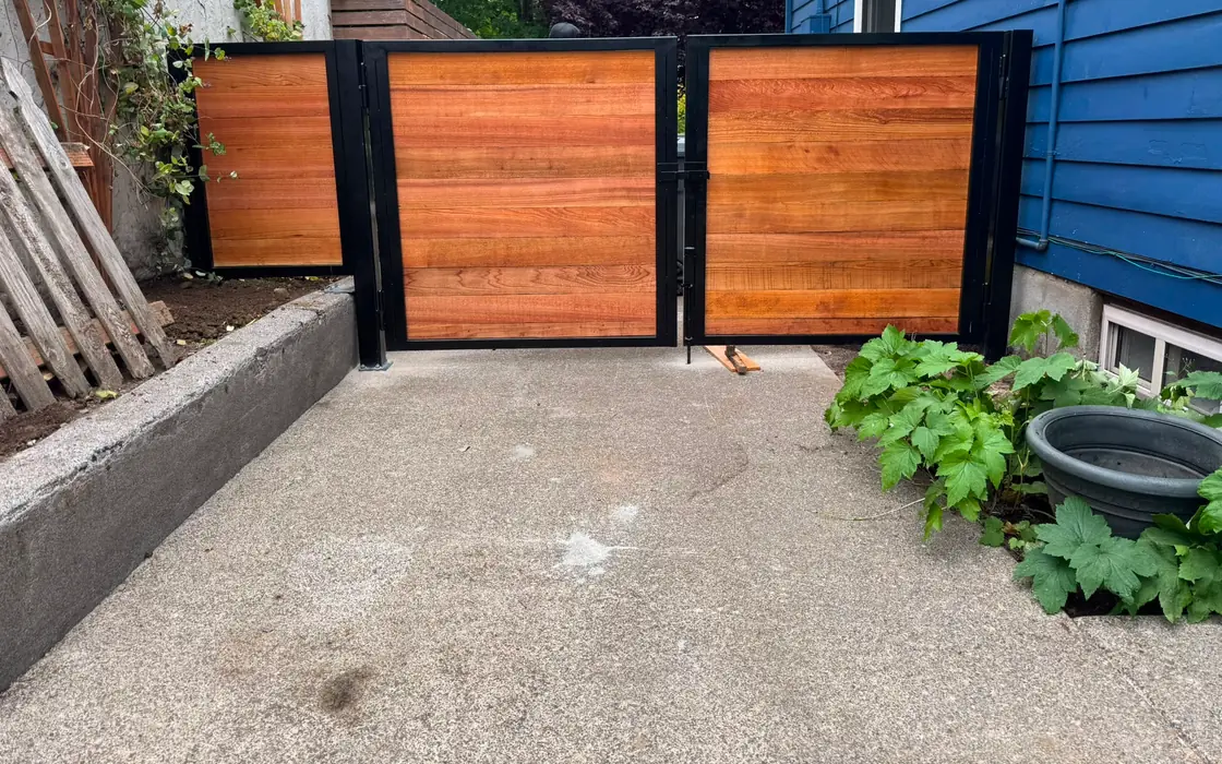 Horizontal cedar swing driveway gate with steel frame, angled side-yard view. Fence & gate installation in Washougal
