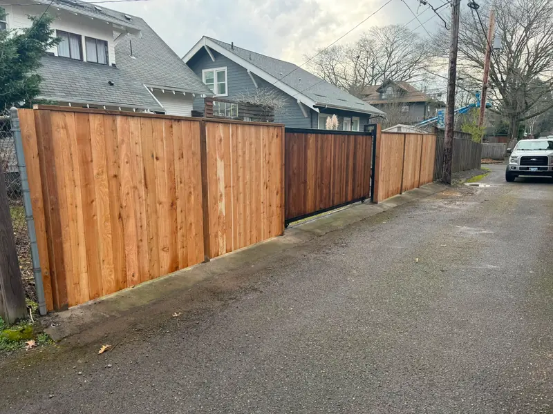 Cedar privacy fence. Long cedar privacy fence with slide gate along alley, work truck parked nearby