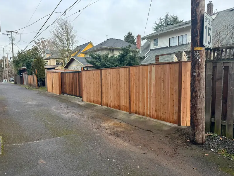Good-neighbor cedar fence. Long new cedar privacy fence with integrated slide gate along residential alley