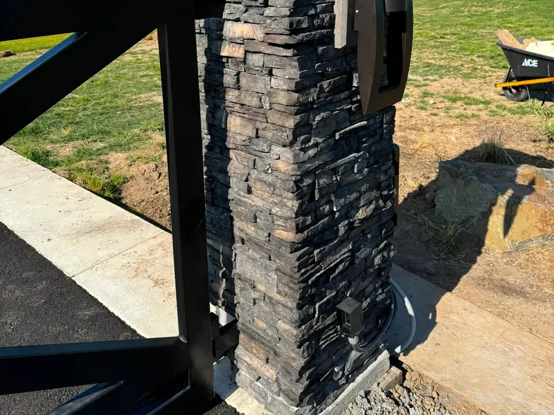 Stacked-stone gate columns. Close view of stacked-stone gate column with intercom and gate leaf